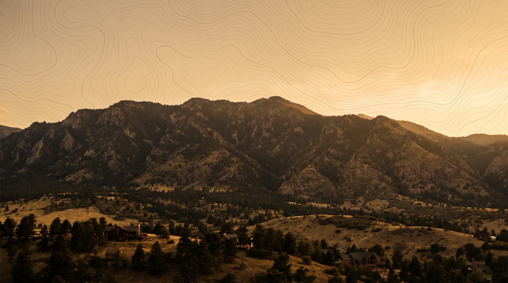 The forested Cheyenne Mountain massif rising over the southwest Colorado Springs foothills at dusk