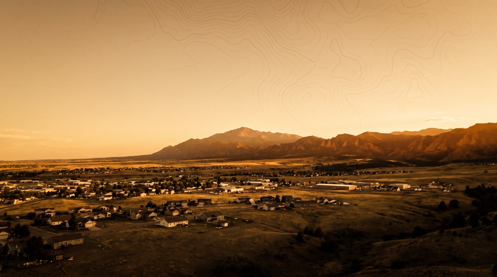 The town of Fountain spread across the southern plains with the Front Range catching sunset light near Fort Carson, Colorado